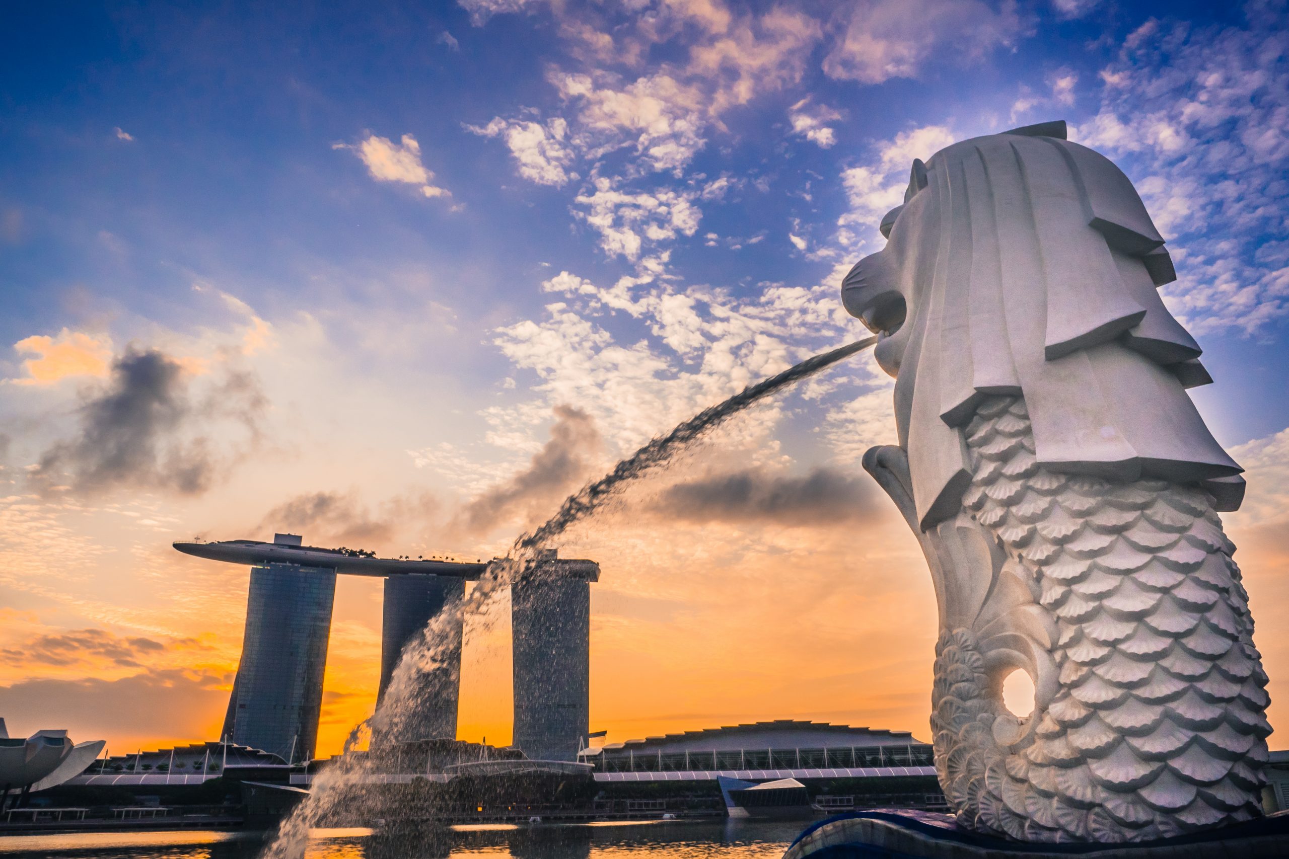 O Merlion visto de trás com vista para o Stonehenge moderno Cingapura